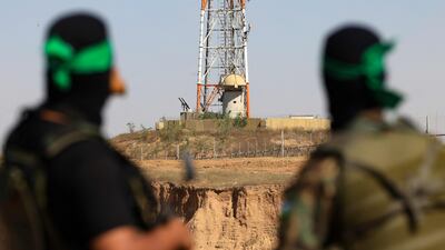 Palestinian fighters of Al Qassam Brigades, the armed wing of the Hamas movement, look towards an Israeli army post near the border in the central Gaza Strip. AFP