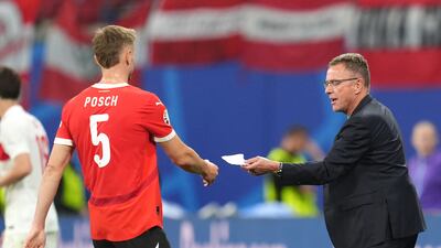 Austria manager Ralf Rangnick passes Stefan Posch a note during the game. PA