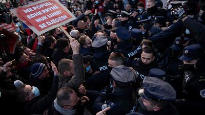 A proster holding a placard reading “Don't play with people and electricity, you can get burnt” scuffles with Kosovo police officers during a protest in Pristina against the increase of electricity prices in Kosovo. AFP