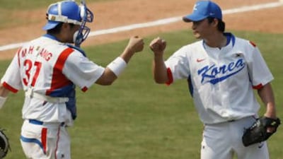 South Korea's closer Oh Seung-hwan, right, and catcher Kang Min-ho react after beating Cuba 7-4 in their baseball preliminary game at the Beijing 2008 Olympics in Beijing, Tuesday, Aug. 19, 2008.