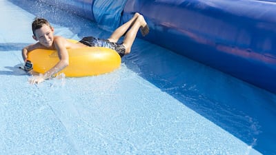A little boy slides down the water slide at Dubai Autodrome. Reem Mohammed / The National