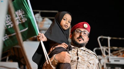A member of the Saudi Navy carries a child from a ship at Jeddah's port during the kingdom's evacuation of civilians from Sudan. Reuters