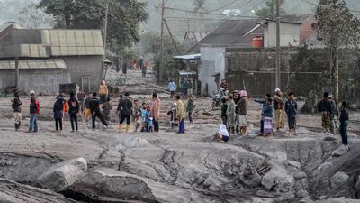 Villagers inspect an area buried in volcanic ash. EPA