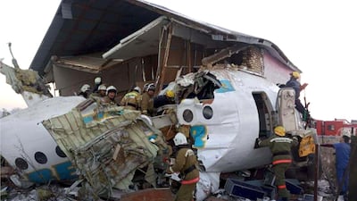 In this handout photo provided by the Emergency Situations Ministry of the Republic of Kazakhstan, police and rescuers work on the side of a plane crash near Almaty International Airport, outside Almaty, Kazakhstan. Almaty International Airport said the Friday crash of a Bek Air plane in Kazakhstan has caused numerous deaths. The aircraft had 100 passengers and crew abroad, and hit a concrete fence and a two-story building shortly after takeoff. AP