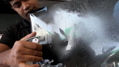 The installation process of V-Kool’s protective window film at the company’s main workshop on the outskirts of Al Quoz industrial area in Dubai. Satish Kumar / The National