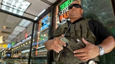 Private security guard Gus Rodriguez stands outside the Palacio de Oro jewellery store in Los Angeles. Damian Dovarganes / AP Photo