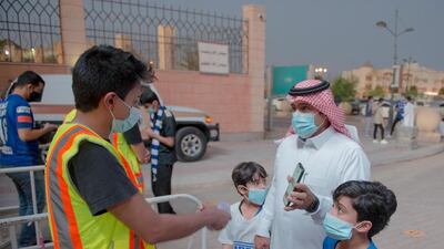A man and two children enter the Prince Faisal bin Fahad stadium in Riyadh. SPA