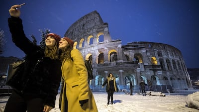 Tourists take a selfie in front of the Colosseum covered by snow during a snowfall in Rome, Italy. Angelo Carconi / EPA