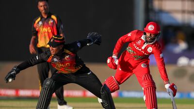 Oman's Aqib Ilyas runs to make his ground as Papua New Guinea's Kiplin Doriga takes the ball. AP