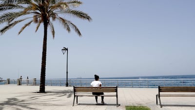 A woman sits on a bench along the seaside corniche of the Lebanese capital Beirut, as a lockdown imposed by the authorities during the coronavirus pandemic begins to ease. AFP