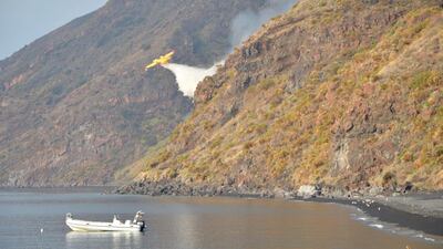 A Canadair plane drops water after the Stromboli volcano eruption started forest fires, in Stromboli, Italy. Reuters