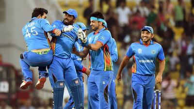 Afghanistan's players celebrate after the wicket of West Indies's batsman Andre Russell during the World T20 cricket tournament match between West Indies and Afghanistan at The Vidarbha Cricket Association Stadium in Nagpur on March 27, 2016. / AFP