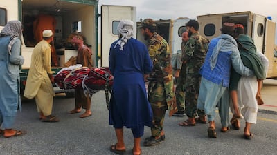 Taliban soldiers and civilians carry earthquake survivors to an ambulance at an airport in Jalalabad. Reuters