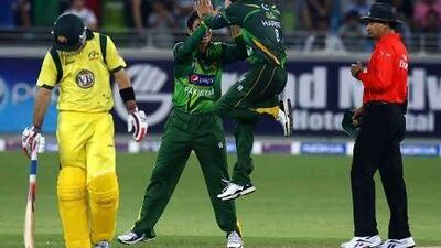 Pakistan players Saeed Ajmal and Muhammad Hafeez celebrate the dismissal of Australian batsman Glenn Maxwell during the first T20 at the Dubai Cricket Stadium. Satish Kumar / The National