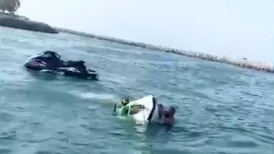 A screen grab from a video released by Dubai Police showing officers rescuing a man who crashed his jetski into the breakwater at Al Mamzar Beach Park. Courtesy Dubai Police
