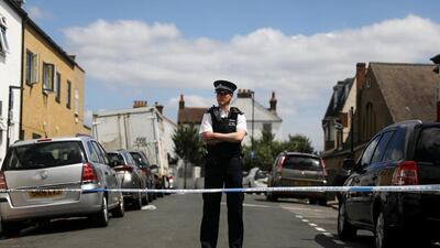 A police officer stands guard in the street where a heavily pregnant woman was stabbed to death in south London. Reuters