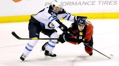 Winnipeg Jets Tobais Enstrom (C) and Florida Panthers Stephen Weiss (R) fight for the puck during the third period of their NHL hockey game in Sunrise, Florida April 3, 2012. REUTERS/Rhona Wise (UNITED STATES - Tags: SPORT ICE HOCKEY) *** Local Caption *** RWW10_NHL_0404_11.JPG