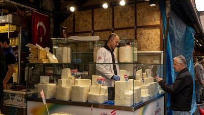 A customer at a cheese and fresh produce store in Istanbul