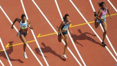 France's Muriel Hurtis-Houairi, left, Muna Lee of the USA and Cayman's Cydonie Camille Mothersill compete during the women's 200m heats.