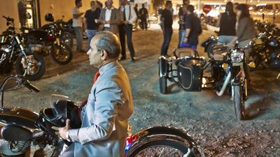 A suited Gentleman sits astride his custom Build Royal Enfield motorcycle outside Cafe Rider in Al Quoz for the start of the Distinguished Gentleman’s Ride 2014 in Dubai.