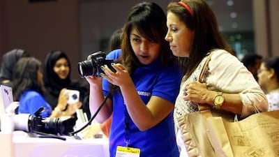 Visitors to the Gitex show examine a digital camera. More than 3,500 visitors came through the doors within the first hour, according to organisers. Satish Kumar / The National