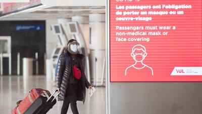 A woman wears a face mask as she walks through Montreal–Trudeau International Airport, as the Covid-19 pandemic continues in Canada and around the world. AP