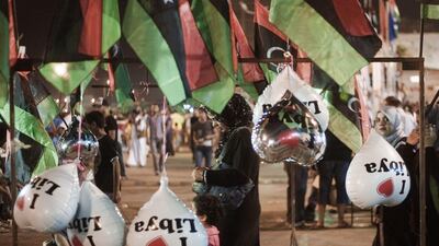 A Libyan woman walks with kids through vendors kiosks at Freedom square on August 22, 2011 in Benghazi, Libya. Tripoli residents spent Monday jubilant yet fearful, asking for weapons to join rebels in their cat-and-mouse war with loyalists who have besie???