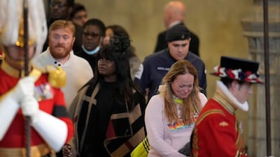 Members of the public pay their respects as they pass the coffin of Queen Elizabeth II, lying in state inside Westminster Hall, London. AFP