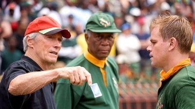 Director Clint Eastwood, left, talks with Matt Damon, right, playing the South African rugby captain, and Morgan Freeman on the set of Invictus