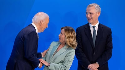 Mr Biden and Mr Stoltenberg greet Italian Prime Minister Giorgia Meloni on stage before a group photo. Getty Images / AFP