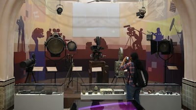 A student takes pictures of old camera and lighting equipment on display at the National Museum of Indian Cinema. AFP