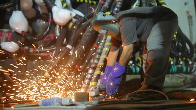 A labourer uses a metal cutting machine. EPA
