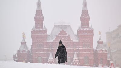 A woman crosses Red Square during a heavy snowfall in Moscow with the State Historical Museum in the background. AFP