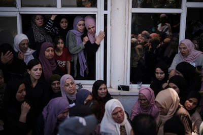 Mourners hold a funeral for three Palestinians killed when settlers stormed a West Bank village. AP