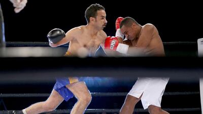 Ahmed Al Ali, in white, and Mohammed Abbas trade blows during their boxing match at Yas Island in Abu Dhabi. Ali won the match. Sammy Dallal / The National