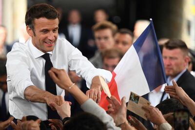 French President Emmanuel Macron, who is seeking re-election, shakes hands with supporters on the last day of campaigning, in Figeac, southern France. AFP
