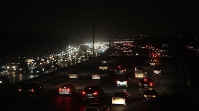 Vehicles drive on a main highway that was engulfed with darkness in Kuwait City on February 11. AFP Photo