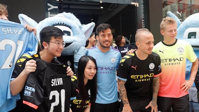 David Silva, Angelino and Oleksandr Zinchenko take pictures with fans during a promotional event in Hong Kong. Reuters