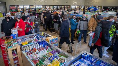People queue to buy food at a petrol station in Pflugerville, Texas. Most homes in the area had been without electricity for nearly eight hours. Power companies performed rotating cuts to protect the grid. AP