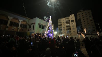 Gaza city residents attend the lighting of the Christmas tree, in an event organised by the YMCA Christian youth association.