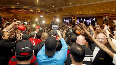 Manny Pacquiao is swarmed by a crowd and reporters and photographers last year while in Las Vegas for his fight against Timothy Bradley. Mike Young for The National / April 9, 2014