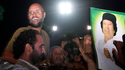 Moammar Gadhafi's son, Seif al-Islam, top left, gestures to troops loyal to his father in Tripoli, Libya, Tuesday, Aug. 23, 2011. Seif al-Islam, who was earlier reported arrested by Libya's rebels, turned up early Tuesday morning at the hotel where foreign journalists stay in Tripoli, then took reporters in his convoy on a drive through the city. (AP Photo/Imed Lamloum, Pool)