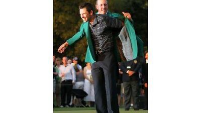 Charl Schwartzel is given his green jacket by last year's Masters winner Phil Mickelson.