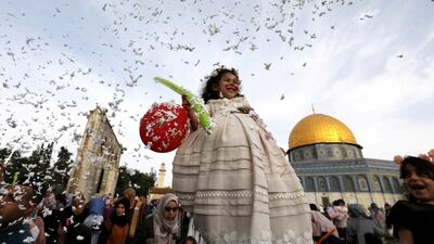 Foam is sprayed as a girl smiles during celebrations after Palestinians performed Eid al-Fitr prayers. Reuters