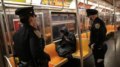 New York City Police officers wake up a passenger on the subway. Reuters