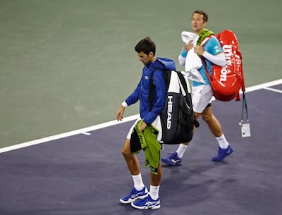 Novak Djokovic and Philipp Kohlschreiber make their way off the court due to rain after one game of their match at Indian Wells. EPA