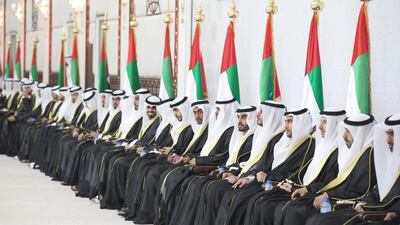 The grooms sit in a row at the group wedding. Donald Weber / Crown Prince Court - Abu Dhabi