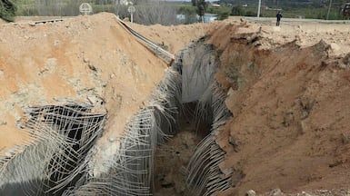 A man stands near the crater the day after an Israeli air strike on the Qasmiyeh Bridge on a main motorway linking villages in the Tyre district with others farther north, after Israel said the bridge was being used by Hezbollah, in southern Lebanon. AFP