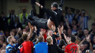 Huddersfield Town players throw manager David Wagner in the air as they celebrate staying in the Premier League. Matthew Childs / Reuters