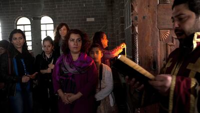 Armenian women pray and light candles during Easter Sunday mass at Surp Giragos Ermeni Kilisei in Diyarbakir, Turkey. The church, which had fallen into ruin after the 1915 Armenian Genocide and the pogroms that followed it, was recently renovated and Armenians, many of whom were the children and grandchildren of those who had been forced to flee Diyarbakir, came from all around the world in order to celebrate Easter at their ancestors' church. Courtesy Scout Tufankjian